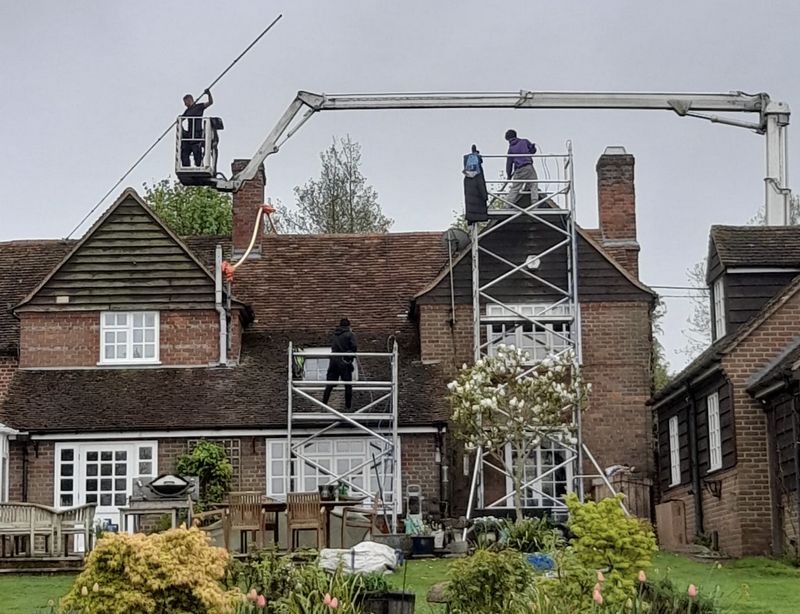 The Moss Cleaners using cherry picker and scaffolding to clean roof safely and professionally in Brentford, {{COUNTY}}